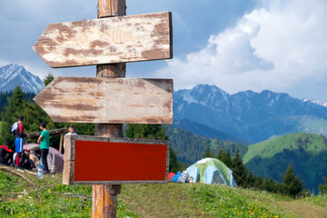 Pointer with direction in the mountains. Directional signs against mountains.