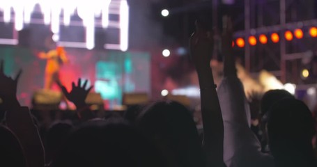 people watch band performing on the stage on music festival young people waving hands enjoy the rap music live show