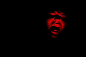 Maniac face silhouette illuminated by torch on black background. Dark background. Horror background. Black background. Halloween horror concept. - obrazy, fototapety, plakaty