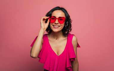 Females holidays. Beautiful trendy happy glamorous young woman in fashion wears and cool glasses in pink vivid style.
