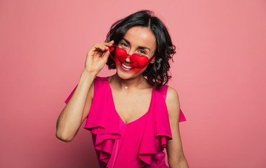 Females holidays. Beautiful trendy happy glamorous young woman in fashion wears and cool glasses in pink vivid style.