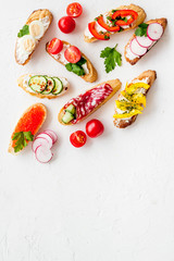 Sandwiches - set with vegetables, caviar, salami - on white background top-down copy space