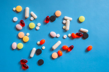 Different colorful many pills in abstract style. Healthy background. Health care, medical concept. Blue background.