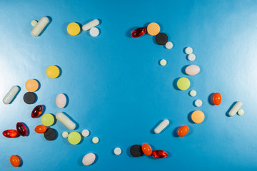 Different colorful many pills in circle shape. Healthy background. Health care, medical concept. Blue background.