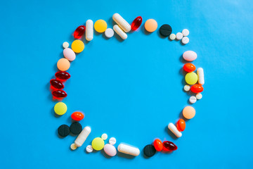 Different colorful many pills in circle shape. Healthy background. Health care, medical concept. Blue background.