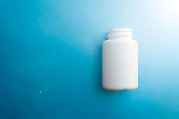 Closeup of white pill bottle on blue background.Health care, medical concept.