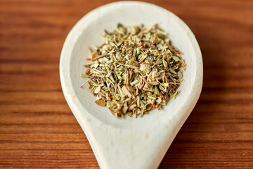 food, culinary and unhealthy eating concept - close up of dry spices on wooden spoon