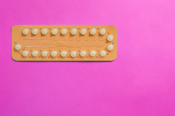 Contraception pills on pink background. Female contraceptives concept. Bitrh control concept.