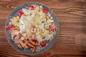 Caesar salad with roasted chicken and tomatoes.