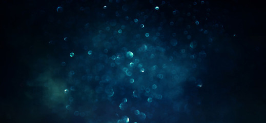 background of abstract glitter lights. gold, blue and black. de focused
