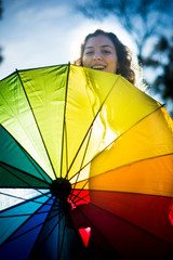Beautiful woman with umbrella of many colors in backlight on a sunny day © Antonio Sanchez