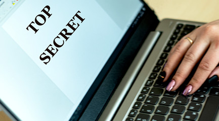 concept words top secret written by a girl on a laptop