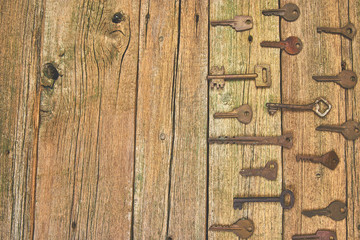 Collection of many different old retro keys in order on wooden rustic background concept. Creative...