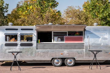 Classic chrome food wagon in park. Food truck.