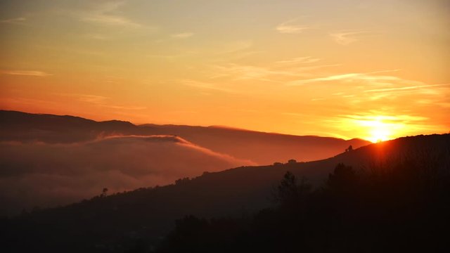 Beautiful dawn and sunrise over the mountain hill peaks. The orange color of the timeless beauty sky.