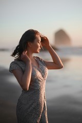 Fototapeta na wymiar Girl in evening dress at sunset on the ocean, Oregon. Cannon Beach. Femininity