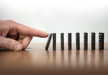 dominoes are knocked over with one finger