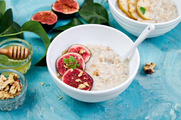 A bowl of porridge with figs slices and walnuts