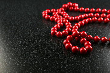 red beads on black background with copy space