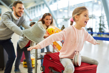 Lachendes Mädchen und Familie im Flughafen