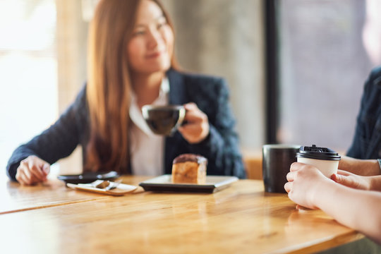 Closeup image of people enjoyed talking, eating and drinking coffee together in cafe