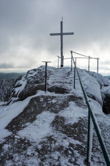 The peak of mountain "Jizera". Snowed cross on the top. Frozen and snowed landscape.