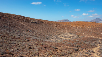 Elevated views of the arid volcanic landscape surrounding the summit of Montana Amarilla towards Pico del Teide and the small terraced villages, in Costa del Silencio, Tenerife, Canary Islands, Spain