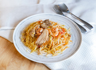 Top view , Singapore noodles on table, Favorite Asian Street food, Homemade stir fried rice vermicelli noodles with pork and shrimps.