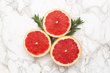 Grapefruits with rosemary on marble background, fruit flatlay, summer minimal compositon