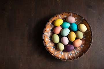  Bowl with colorful easter eggs on wooden table. Space for text. Happy Easter. 