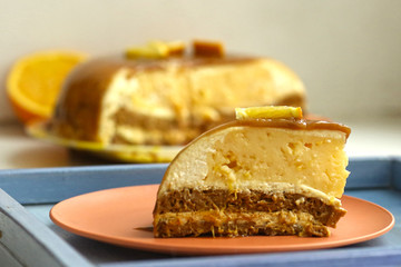 cut orange caramel mousse cake with cream cheese mascapone and chocolate glaze with nuts close up photo