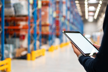 Manager holding digital tablet in warehouse	