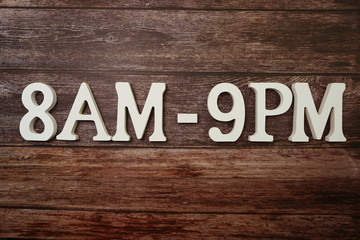 Opening Times 8 am to 9 pm letter on wooden background