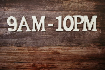 Opening Times 9 am to 10 9pm letter on wooden background