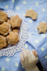 Kids hand take healthy homemade cookies from a pink plate