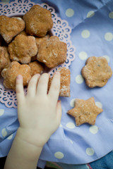 Kids hand take healthy homemade cookies from a pink plate
