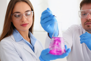 Technician hold in arms in protective gloves sample bottle with poison fluid portrait. Medical worker in uniform use reagent tube for virus infection exam water biological toxic reaction drug creation