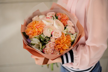 stylish bouquet made of different flowers in woman hands