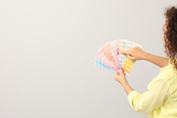 African-American woman with color palettes on grey background