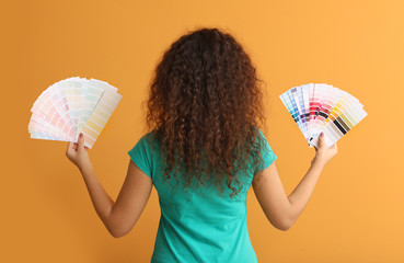 African-American woman with color palettes on orange background