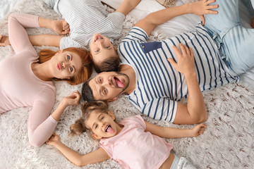 Happy family having fun on bed at home