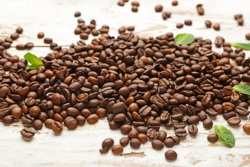 Many coffee beans on wooden background