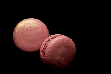 top view of shiny pink french macaroons isolated on black