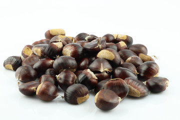 A handful of edible chestnuts separated on a white background. Isolated white background and autumn forest edible brown chestnuts.