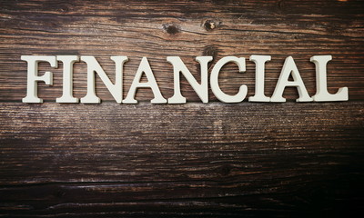 Financial alphabet letter on wooden background