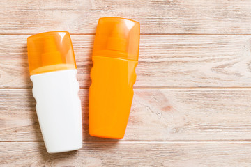 Two Sunscreen bottles on a bright wooden background, top view with copy space