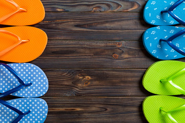 a lot of flip flop colored sandals, summer vacation on wooden background, copy space top view
