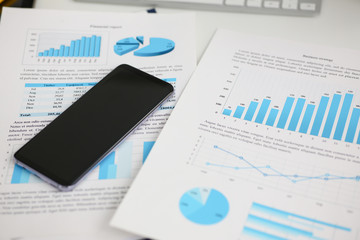 Smartphone calculator and financial statistics ondisplay tablet at office table closeup. Internal Revenue Service inspector sum check irs investigation earnings savings loan and credit concept