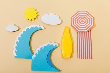 Top view of paper cut summer beach with tube of sunscreen on beige background
