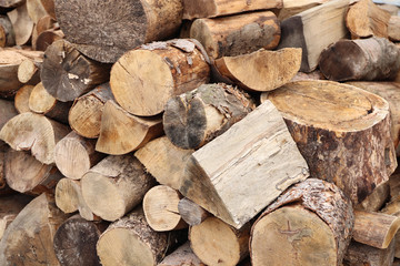 Sawing wood and preparing firewood for winter. Stacked pieces of wood on top of each other.